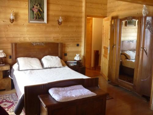 une chambre avec un lit dans une cabane en rondins dans l'établissement SCI Chalet Dempure, à Isola 2000