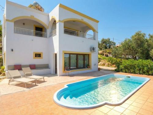 a villa with a swimming pool in front of a house at Villa Anafoufou Afionas with private heatable pool in Afionas