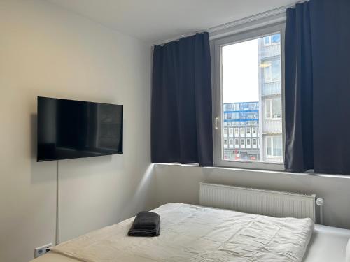 a bedroom with a bed and a flat screen tv at Noble Rooms Saarbrücken in Saarbrücken