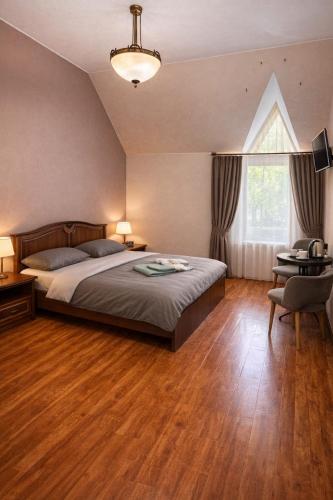 a bedroom with a bed and a desk and a window at Отель Ренессанс in Dnipro