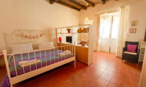 a bedroom with a bed and a chair and a window at La Piazzetta in Syracuse