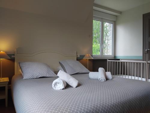 a bedroom with a bed with white pillows on it at Gîtes Les Clairets - Normandie in Mortain