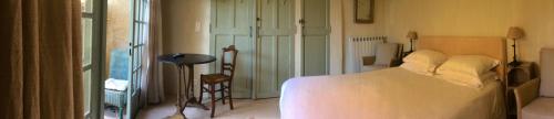 a bedroom with a white bed in a room at Ancienne Maison des Gardes in Lourmarin