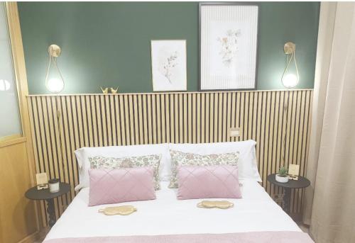 a bedroom with a bed with two pink pillows at Plaza de la Torre in Pontevedra