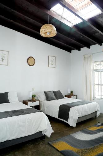 ein Schlafzimmer mit zwei Betten und einem Kronleuchter in der Unterkunft Barón de Huaura Hotel Boutique in Huaura