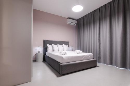 a bedroom with a large bed with white pillows at KAPA Luxury Living in Volos