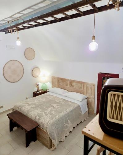 a bedroom with a bed and a table and a tv at Japp'ca Japp'ca in Castellaneta