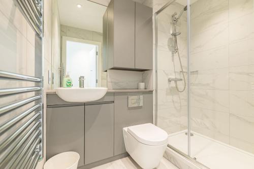 a bathroom with a toilet and a sink and a shower at Grange One By Dublin At Home in Dublin