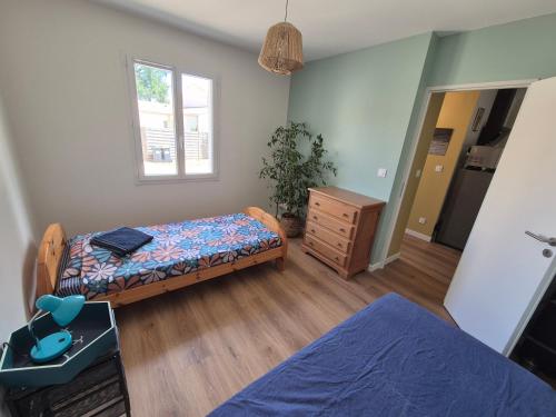 a bedroom with two beds and a dresser and a window at Lisière Hébergements - Casa Mouette Mouette in La Tremblade