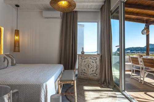 a hotel room with a bed and a balcony at Theasea luxury retreat in Vrachonisída touArchangélou