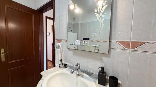 a bathroom with a sink and a mirror at Sunset Hideaway Santa Cruz in Silveira