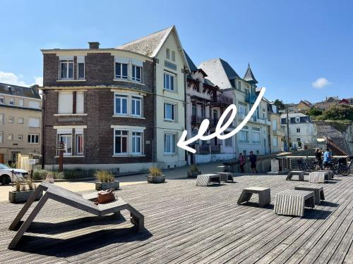 a group of benches on a boardwalk with buildings at L'horizon d'Ault, prêt à séjourner, draps & serviettes inclus, lits faits à l'arrivée in Ault