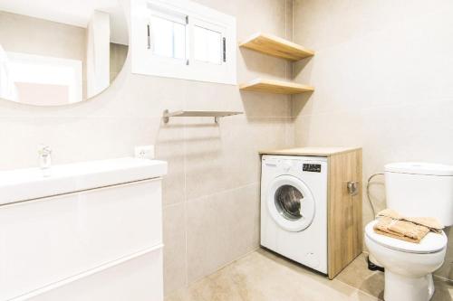 a bathroom with a toilet and a sink and a washing machine at Casa Bodega Coco in Puerto del Carmen