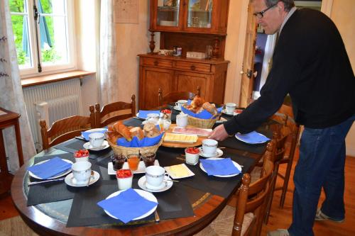 een man die rond een tafel staat waar eten op staat. bij Le Manoir in Souillac