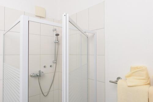 a shower with a glass door in a bathroom at Hotel INNsel26 in Oberhausen