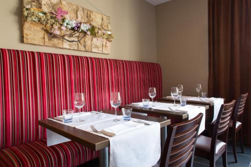 a row of tables in a restaurant with wine glasses at Hotel Malpertuus in Riemst