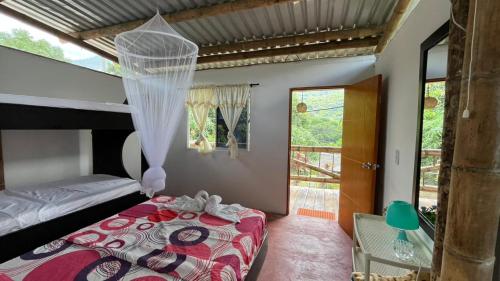 a bedroom with a bed with a mosquito net at Cabaña El Tucan in Minca