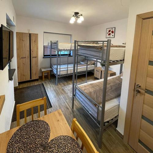 a room with three bunk beds and a table at Somni Apartamente in Chinteni