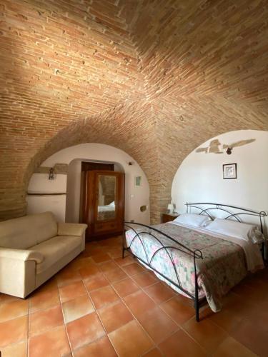 a bedroom with a bed and a couch in a room at Il Casale di Nonna Bambina in Francavilla al Mare