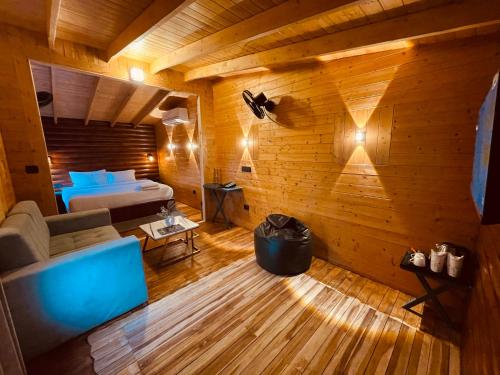 a bedroom with a bed and a couch in a room at Koro Treehouse Resort Luxury Jacuzzi Cottages and Jacuzzi Villas in Kasauli