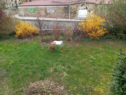 a red chair sitting in the grass in a yard at Les Lavandières in Satillieu