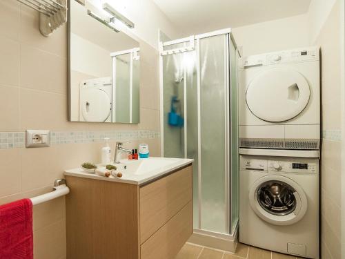 een badkamer met een wastafel en een wasmachine bij Cariddi Loft in Sperlonga