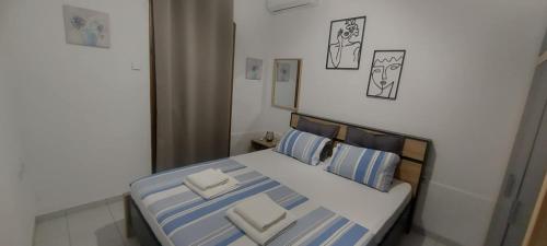 a bedroom with a bed with blue and white pillows at Andre House in Mesimvría