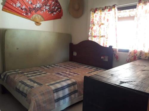 a bedroom with a bed and a wooden table at Sossego e Lazer na Serra do Cipó, piscina e Rio in Jaboticatubas