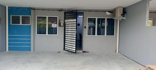 a front door of a house with a blue door at arin syah homestay in Jasin
