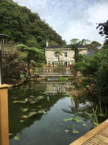 a house and a pond in front of a house at The Waterwheel in St Austell