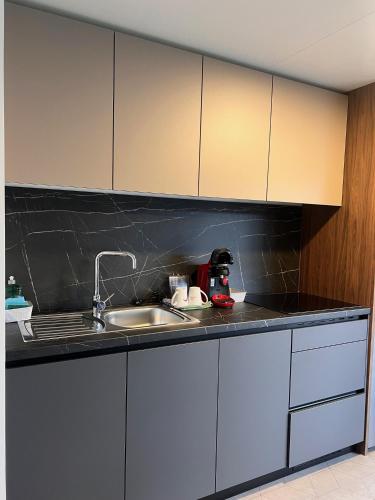 a kitchen with white cabinets and a sink at Camping Resort Riegersburg in Riegersburg