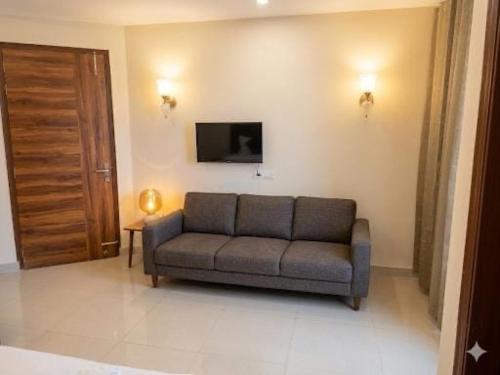 a living room with a couch and a television at Super Townhouse HOTEL SPR ROAD in Gurgaon