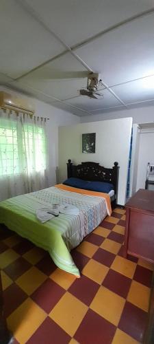 a bedroom with a bed and a checkered floor at Hospedaje Chavela in Barrancabermeja