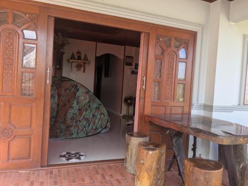a room with a table and a door with a bench at Chez ma mère Homestay in Ko Chetmun
