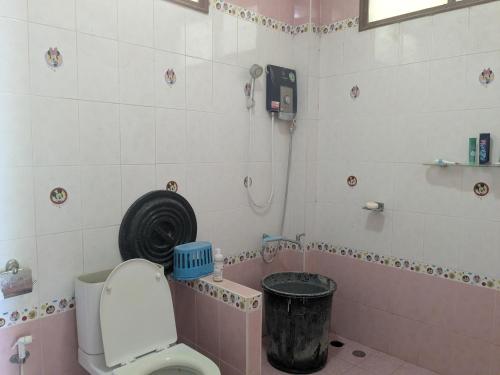 a bathroom with a toilet and a tub with a fan at Chez ma mère Homestay in Ko Chetmun
