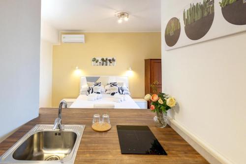 a kitchen with a sink and a bed in a room at Tauromenion Guest House in Taormina