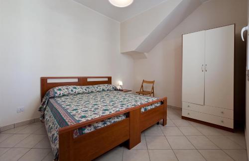 レウカにあるCasa del Sole by BarbarHouseのベッドルーム1室(ベッド1台、キャビネット、椅子付)