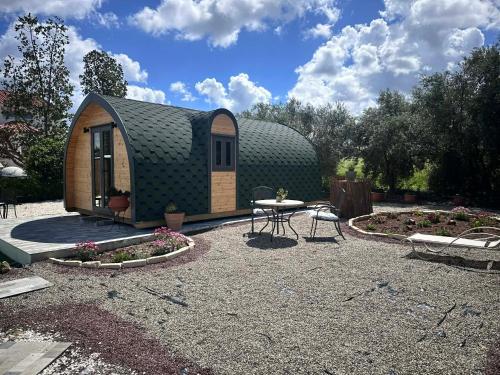 a small shed with a table and a patio at Casa Leandro glamping wooden tiny house in Lachi