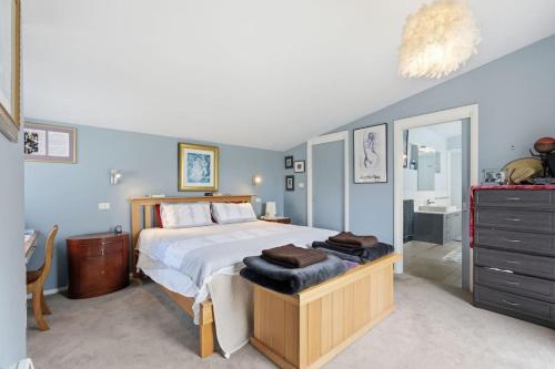 a bedroom with a large bed and a bathroom at Beachfront Beauty Bellerive in Bellerive