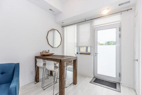 ein Esszimmer mit einem Holztisch und einem Spiegel in der Unterkunft Lake Simcoe Stays - Friday Harbour's Official Rental Program - Beech Suite in Innisfil