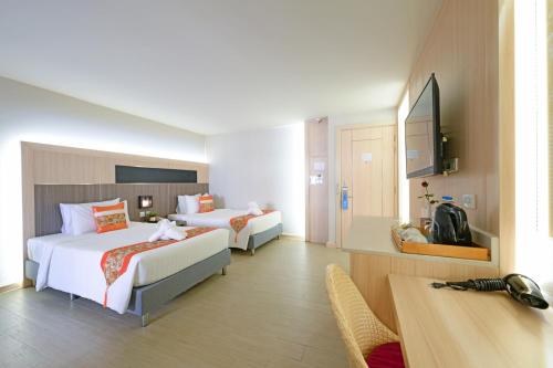 a hotel room with two beds and a television at O2 Grand Suvarnabhumi Airport - Free Scheduled Shuttle from Hotel to Suvarnabhumi Airport in Bang Phli