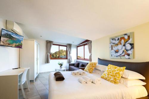 a bedroom with a large white bed with yellow pillows at Tauromenion Guest House in Taormina