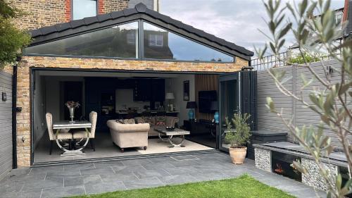 an extension of a garden room with a glass door at Grass Court Terrace - walking distance from Wimbledon Championships in London