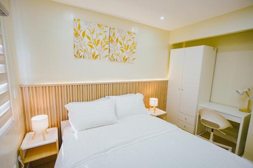 a small bedroom with a white bed and a desk at Silid Pahingahan at Forest Residences in Antipolo