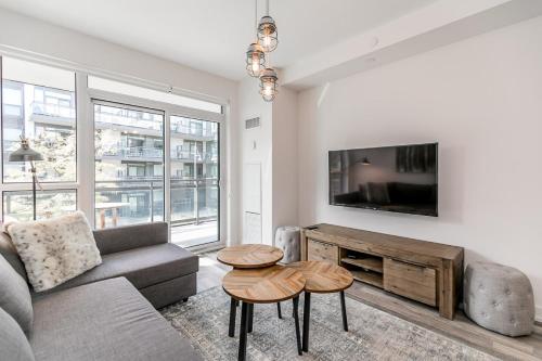 ein Wohnzimmer mit Sofa und Tisch in der Unterkunft Lake Simcoe Stays - Friday Harbour's Official Rental Program - Tamarack Suite in Innisfil