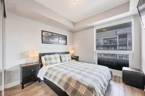 ein weißes Schlafzimmer mit einem Bett und einem Fenster in der Unterkunft Lake Simcoe Stays - Friday Harbour's Official Rental Program - Walnut Suite in Innisfil