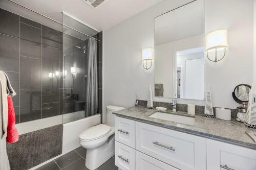 ein Badezimmer mit Toilette, Waschbecken und Spiegel in der Unterkunft Lake Simcoe Stays - Friday Harbour's Official Rental Program - Walnut Suite in Innisfil