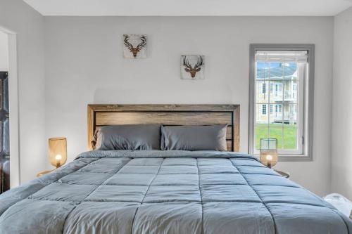a white bedroom with a large bed and a window at Lux Studio in Horseshoe Valley in Shanty Bay