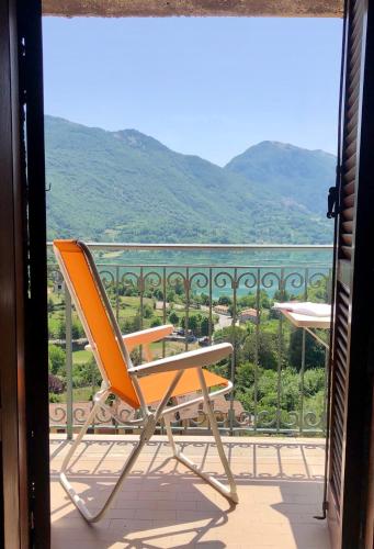 an orange chair sitting on a balcony with a view at Casa con terrazzo vista Lago - LAKEHOLIDAY IT in Castel di Tora