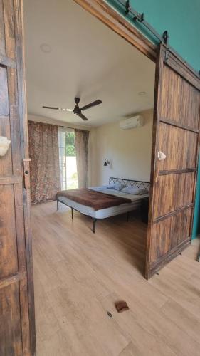 a bedroom with a bed and a wooden door at Baan kratay in Chaloklum